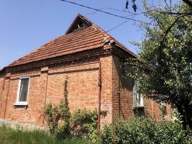 Окремий цегляний будинок біля річки.